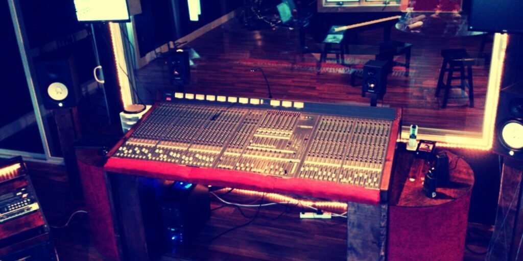 Large mixing console in a professional recording studio with atmospheric lighting