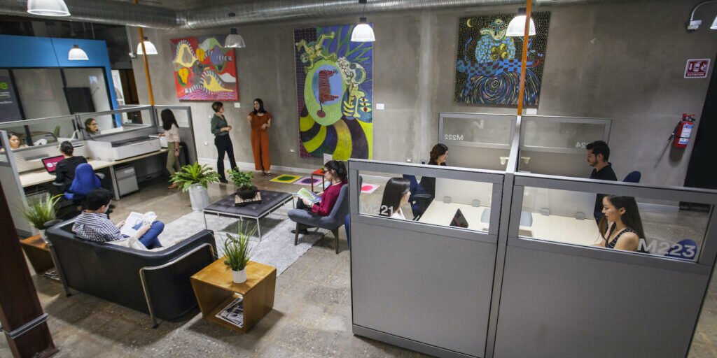 Coworking office space with workers at desks and colorful wall art